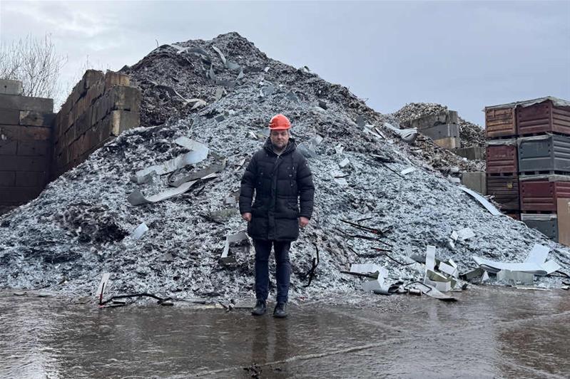 Jérôme Pürro se tient devant un tas de ferraille